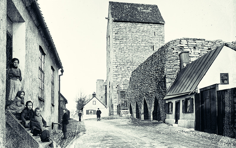 Barn som sitter på en trappa tidigt 1900-tal i Visbys fattigkvarter på Klinten.