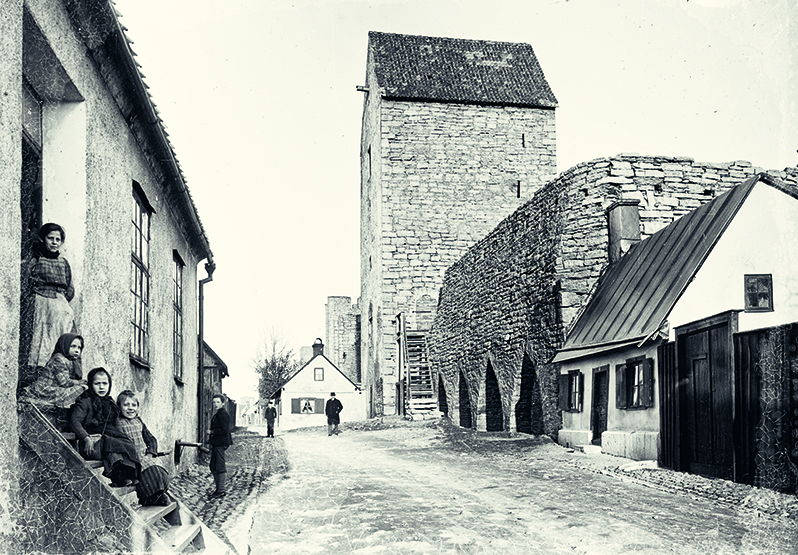 Barn som sitter på en trappa tidigt 1900-tal i Visbys fattigkvarter på Klinten.